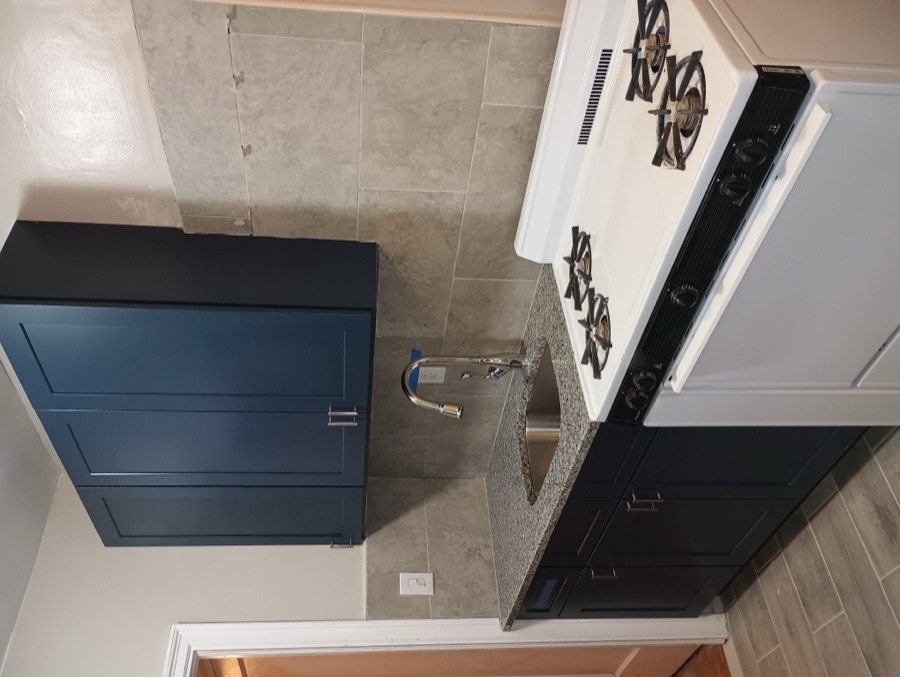 Finished kitchen renovation with navy cabinets and granite countertops